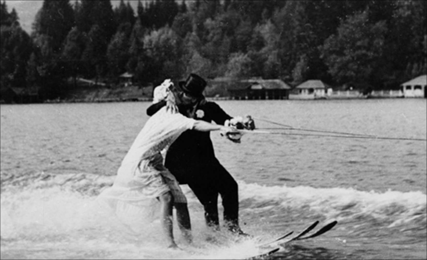kiss while waterskiing in their wedding attire